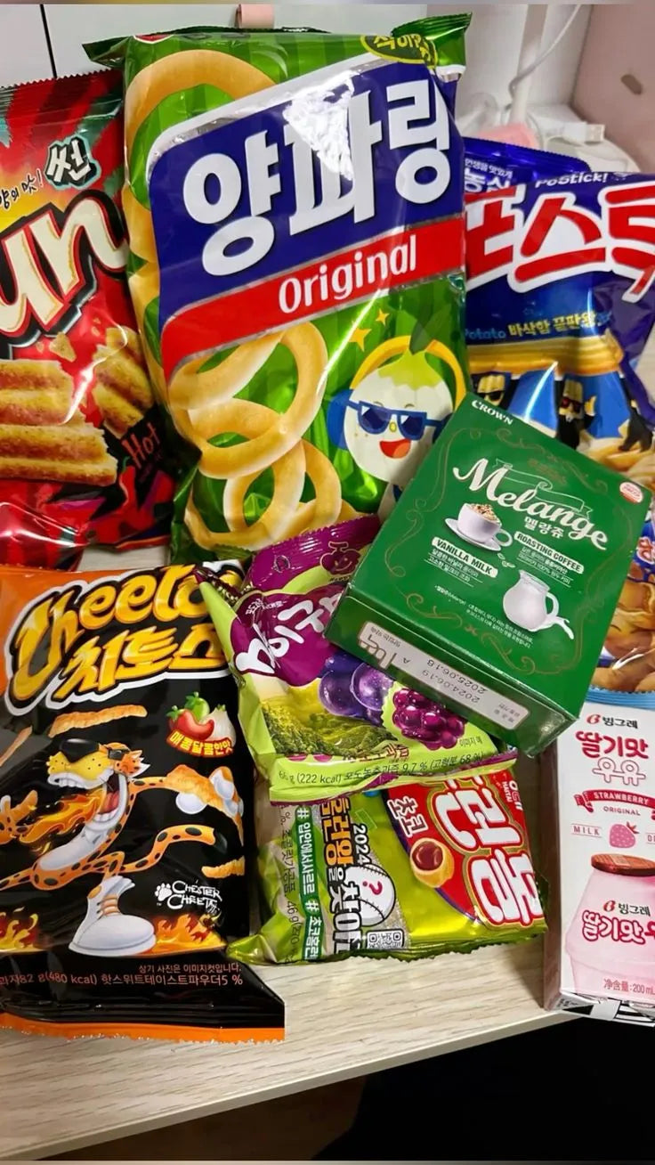 Assorted snacks including cookies, candy, and drinks on a table.